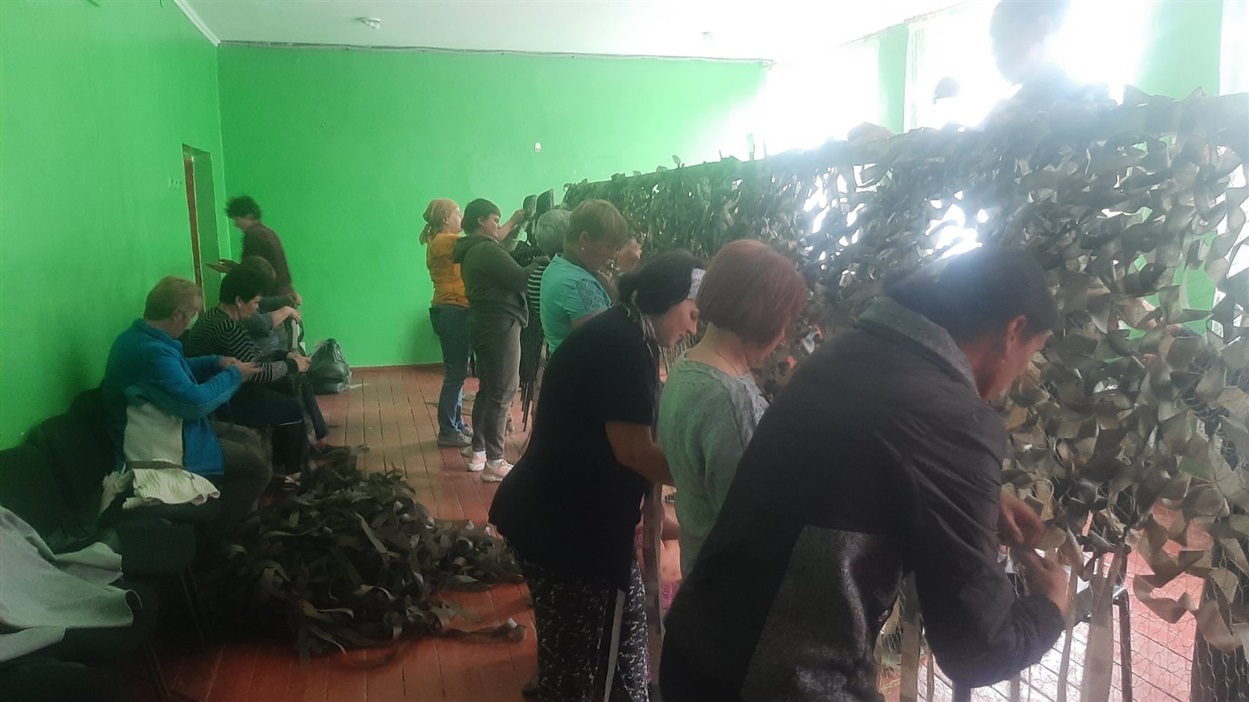 Будейчанки в шкільному спортзалі під час плетіння маскувальних сіток