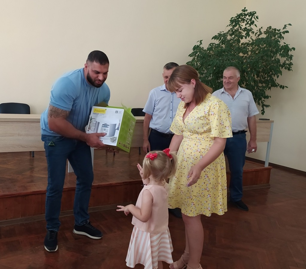 Андрій Васильович Бабенко вручає мультиварку Єві Хузун та його мамі
