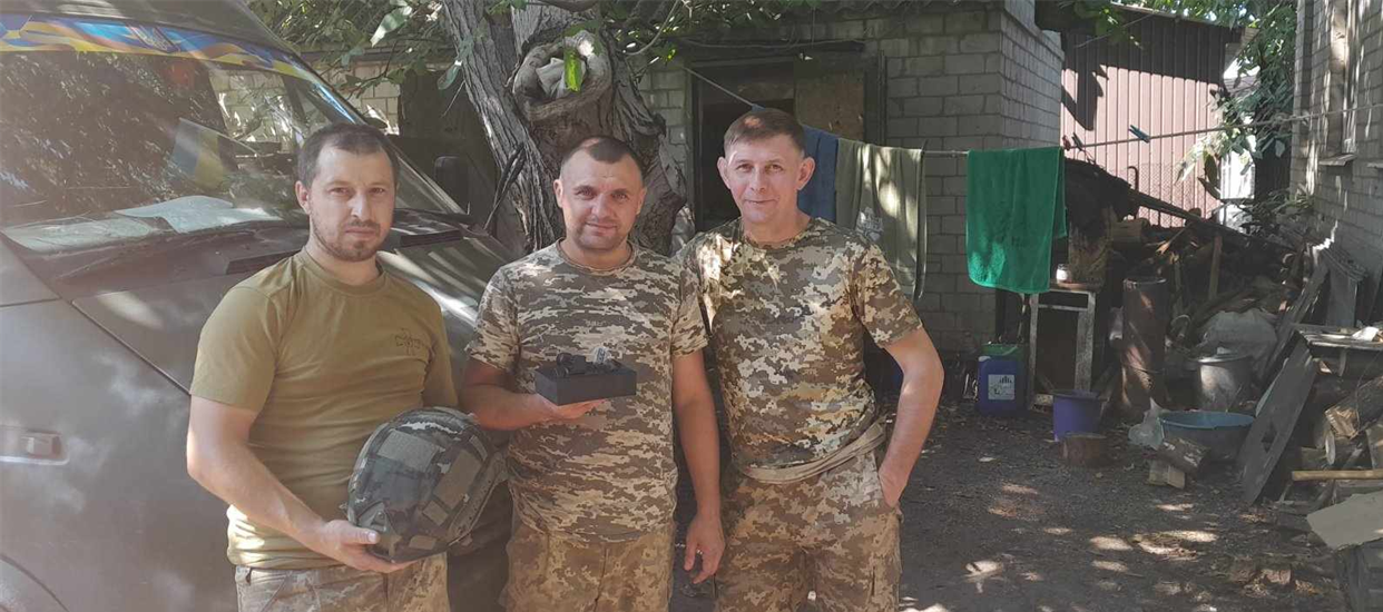 Олег Гедзик з шоломом і бойовими побратимами